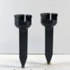 A pair of black plastic candle holders sitting on top of a table.