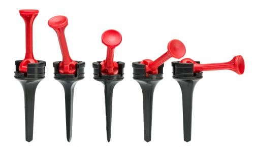 A set of four plastic spigots with red caps.