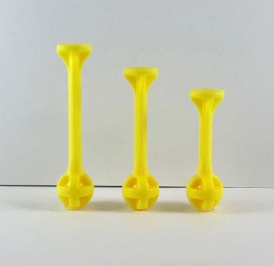 Three yellow plastic objects are sitting on a table.