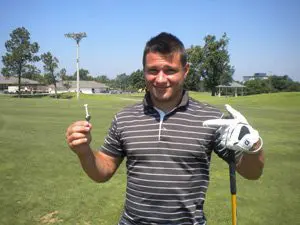 A man holding a golf club and wearing gloves.