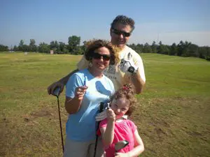 A family is posing for the camera in a field.